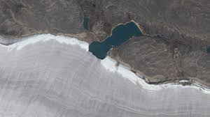 Mini lake meets snowy rim of Canada’s oldest ice mass — Earth from space